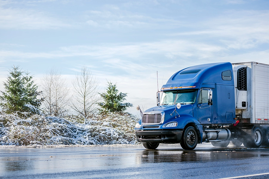 A semi-truck driving along winter roads in Decatur, IL.