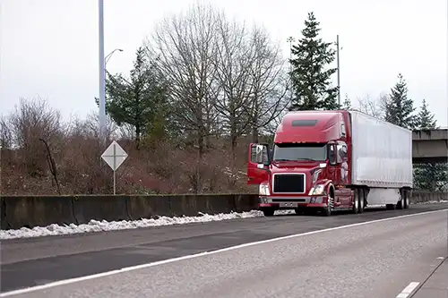 Decatur Trailer Sales & Service - A semi-truck driver is dealing with an emergency breakdown situation and pulls over on the highway in Decatur, IL.