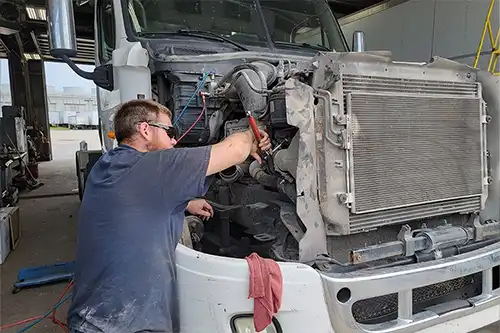 A mechanic at Decatur Trailer Sales & Service working diligently on a client’s diesel engine vehicle in Decatur, IL.