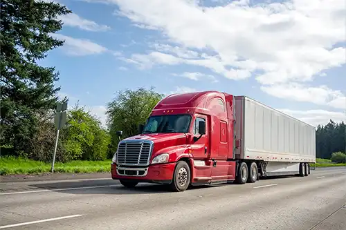 Decatur Trailer Sales & Service - A red commercial trailer travels safely down the road in Decatur, IL