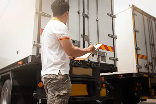 Decatur Trailer Sales & Service Inc. – Person holding a clipboard inspecting a semi-trailer in Decatur, IL.