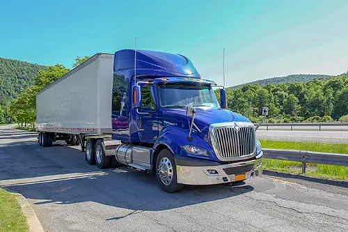 Decatur Trailer Sales & Service—A blue and white semi-truck on a highway in Decatur, Il, preparing for a long haul.
