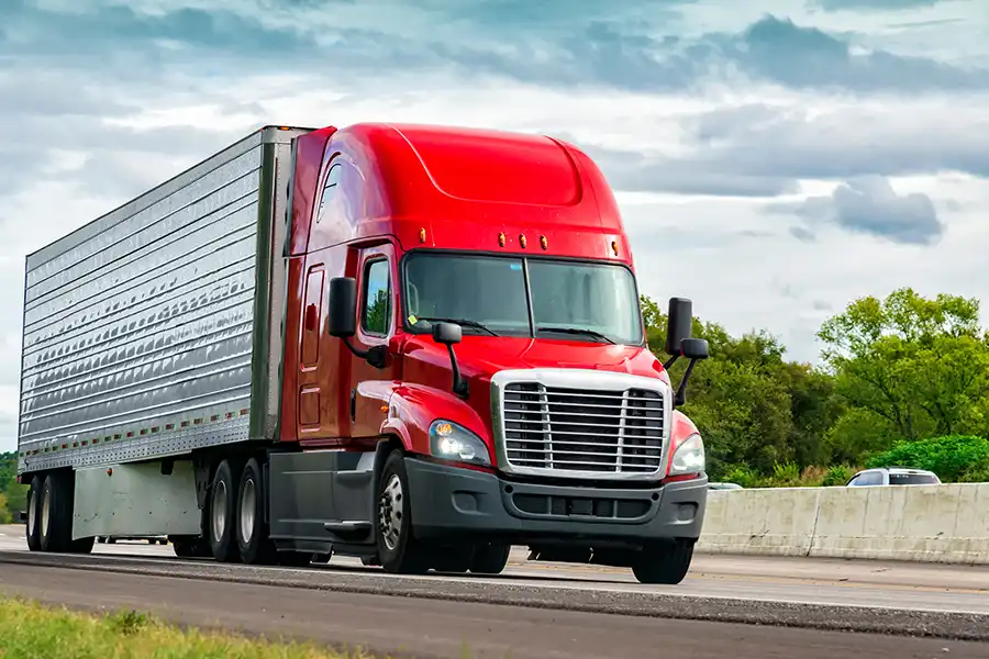 Decatur Trailer Sales & Service Inc.—A red semi-truck drives along a highway in Decatur, IL.