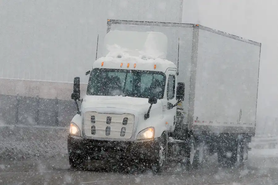 Decatur Trailer Sales & Service—Semi-truck driving down a snowy road during winter in Decatur, IL.