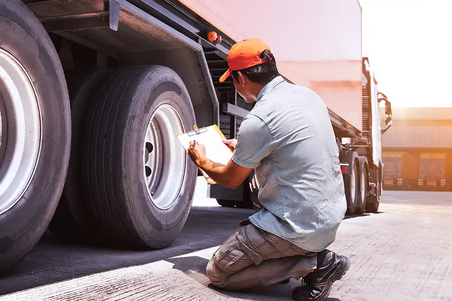 Decatur Trailer Sales & Service—A mechanic checks a semi-truck’s tires for safety at a shop in Decatur, IL.