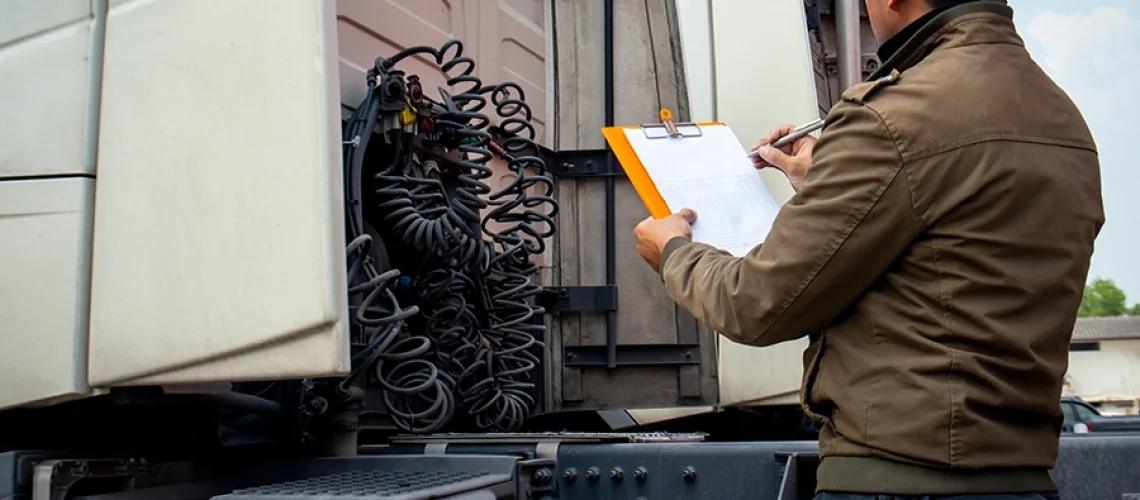 Truck driver going over an inspection on his truck before driving on the road in Decatur, IL.