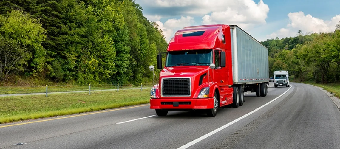 A red semi-trailer driving on the interstate near Decatur, IL, on its way to get trailer maintenance.