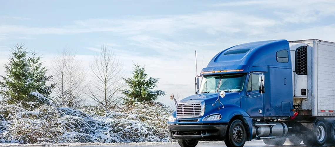 A semi-truck driving along winter roads in Decatur, IL.