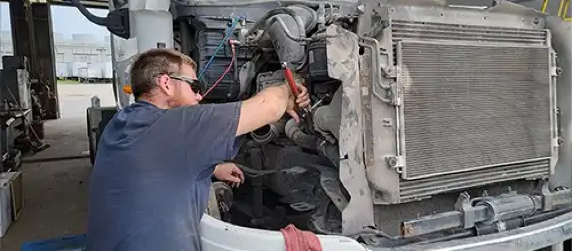 A mechanic at Decatur Trailer Sales & Service working diligently on a client’s diesel engine vehicle in Decatur, IL.