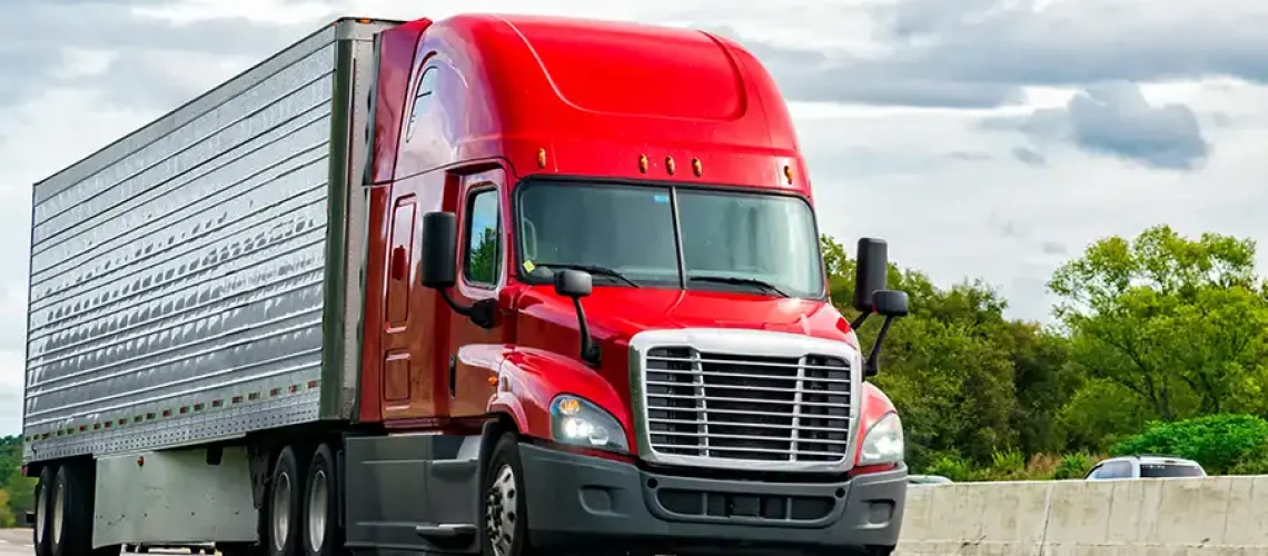 Decatur Trailer Sales & Service Inc.—A red semi-truck drives along a highway in Decatur, IL.