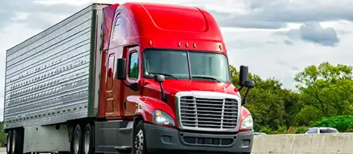 Decatur Trailer Sales & Service Inc.—A red semi-truck drives along a highway in Decatur, IL.