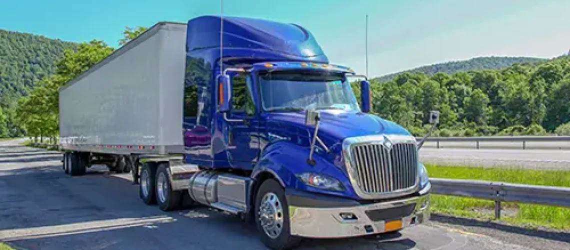 Decatur Trailer Sales & Service—A blue and white semi-truck on a highway in Decatur, Il, preparing for a long haul.
