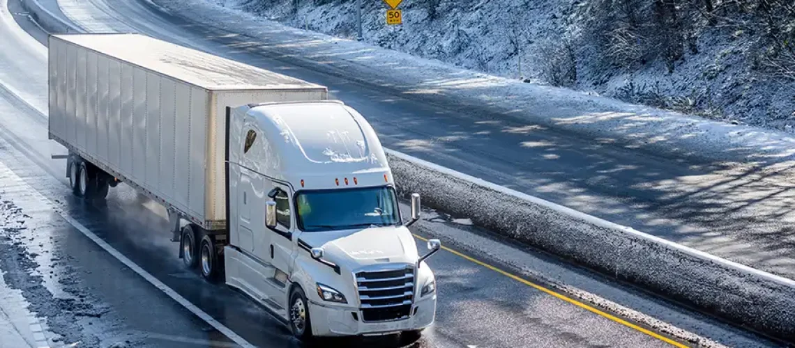 Decatur Trailer Sales & Service—A semi-truck drives down a highway in the snow on a winter day in Decatur, IL.