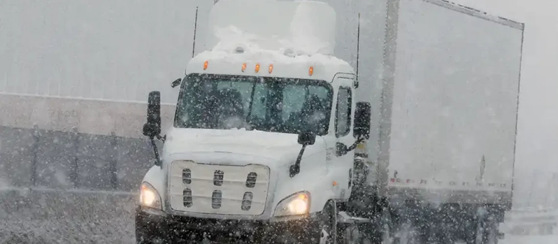 Decatur Trailer Sales & Service—Semi-truck driving down a snowy road during winter in Decatur, IL.