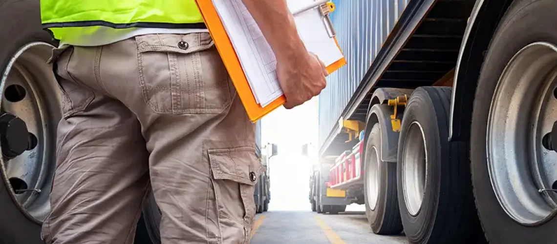 Decatur Trailer Sales & Service—A mechanic with a clipboard checklist stands in front of a semi-truck ready to perform required maintenance in Decatur, IL.