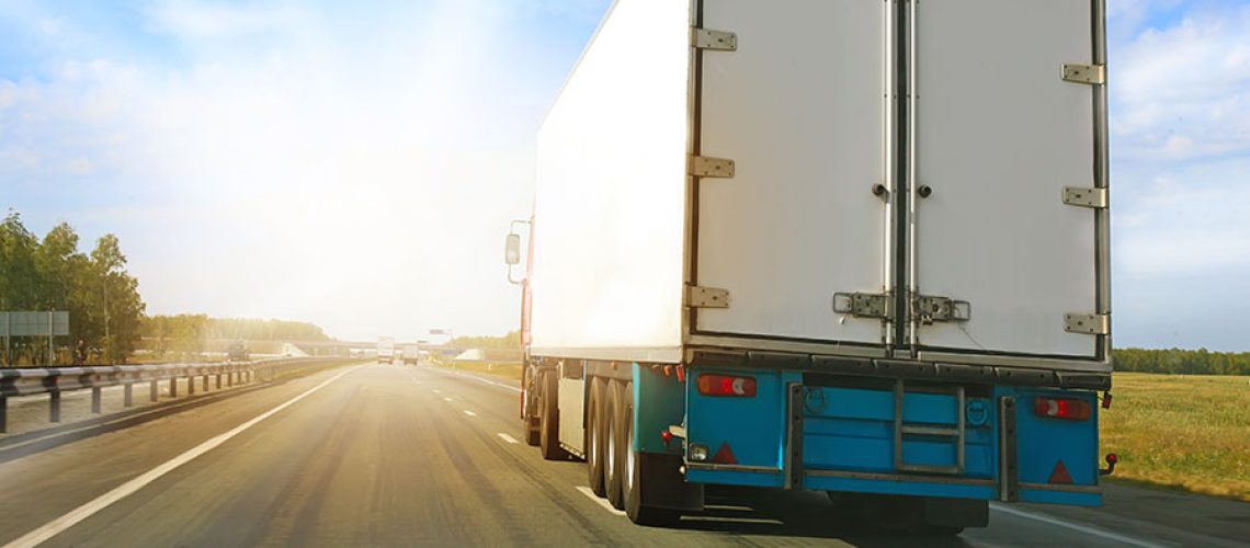 A white semi-truck driving on the road in the afternoon hours towards Decatur, Illinois.