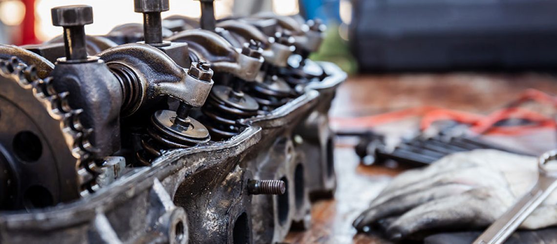 A diesel engine block sitting on a wooden table next to tools in a mechanic shop in Decatur, IL.